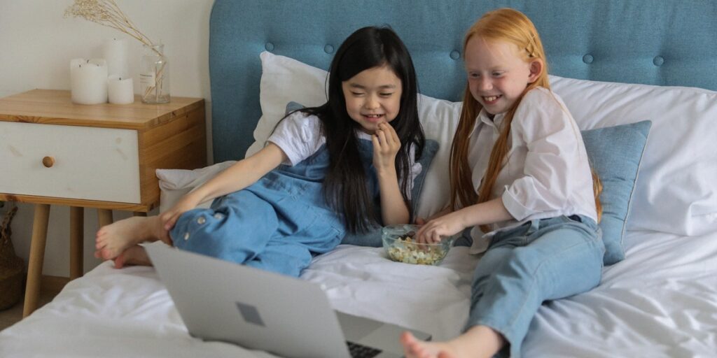 two girls sitting close on bed