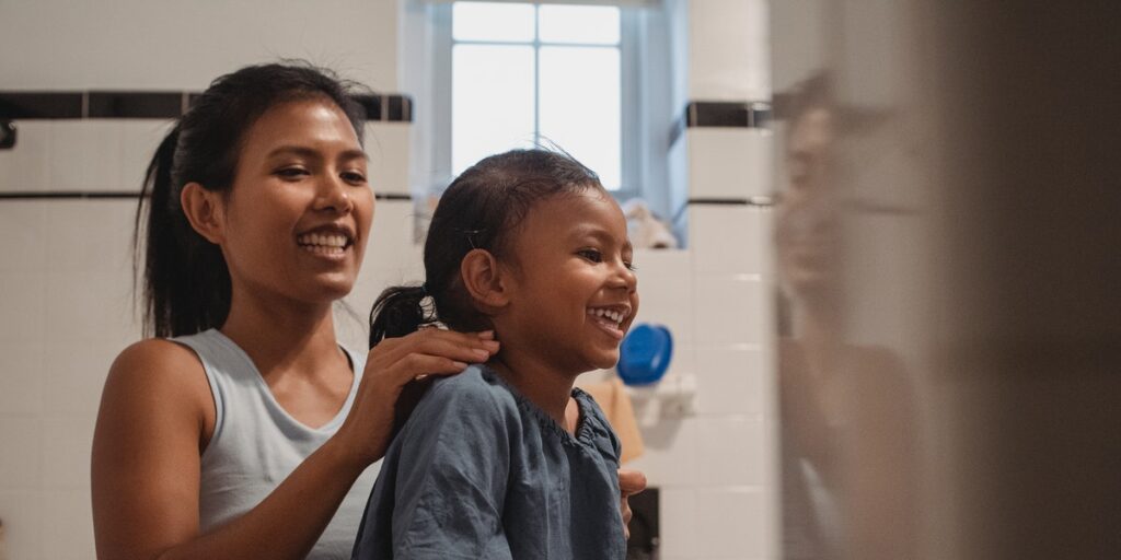 mom brushing child's hair looking for lice